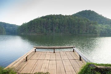 Pier in lake with mountain background.