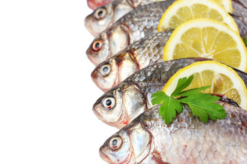 Fresh fishes with lemon and parsley isolated on white