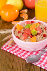 Delicious oatmeal with fruit in bowl on table close-up