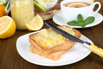 Fototapeta na wymiar Delicious toasts with lemon jam on plate on table close-up
