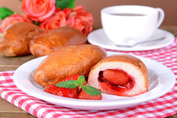 Fresh baked pasties with strawberries on plate on table