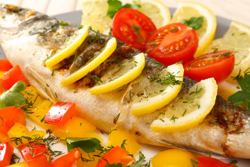 Delicious grilled fish on plate on table close-up