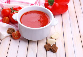 Tasty tomato soup and vegetables on wooden table