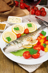 Delicious grilled fish on plate on table close-up