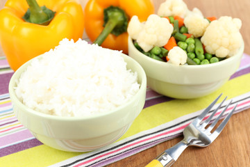 Cooked rice with vegetables on wooden table close up