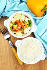 Cooked rice with vegetables on wooden table