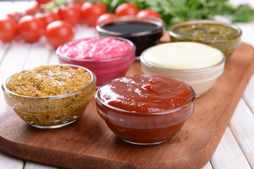 Various sauces on chopping board on table close-up