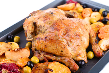 Whole roasted chicken with vegetables on tray, isolated on