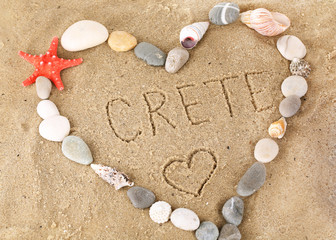 Inscription Crete in wet sand close-up background