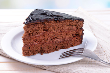 Delicious chocolate cake on plate on table on light background