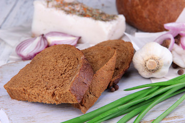 Slices of bread and lard with onion on cutting board close up