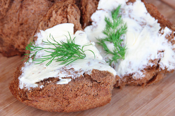 Rye bread with butter on cutting board close up