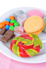 Different sweets on plate on table close-up