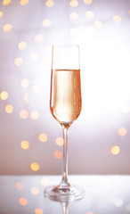 Glass of champagne on shiny background