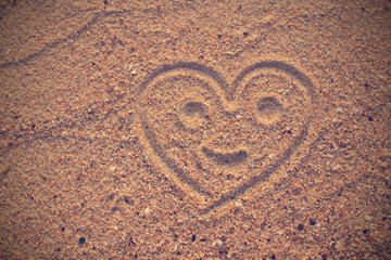 Heart shape drawn on beach sand  in vintage style