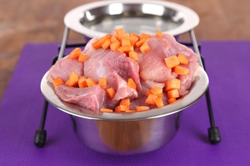 Natural food for pets and water in bowls on floor