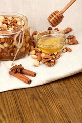 Sweet honey and different nuts on wooden table