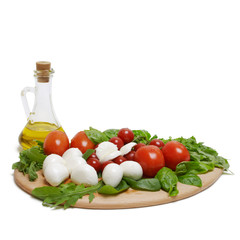 Olive oil with tomatoes,  mozzarella and green basil on a wooden