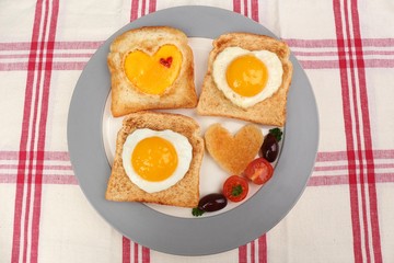 Scrambled eggs with bread on plate, on color napkin