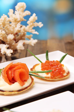 Pancakes with red caviar, salmon and mayo, green onion,