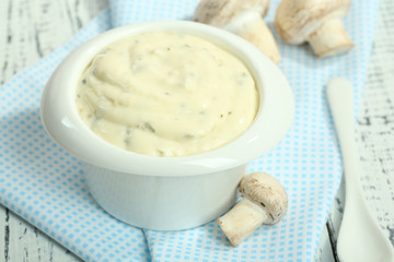 Delicate mushroom sauce in bowl on wooden table close-up