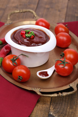 Tomato sauce in bowl on wooden table close-up