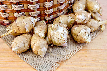 Jerusalem artichokes with a basket and burlap on board