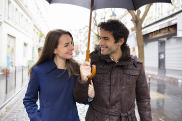 Handsome couple under the rain on street