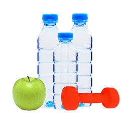 Blue bottles with water, dumbell and green apple isolated on whi