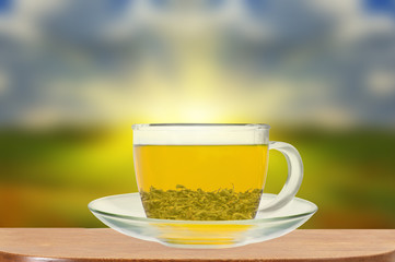 Transparent cup of green tea on wooden table close up