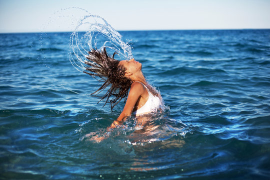 Woman splashing water with her hair.