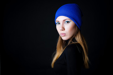 Fashion model with creative blue make up in blue hat