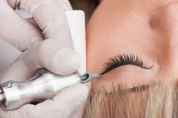 professional tattooist making permanent make-up.
