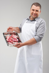 professional butcher holding red meat.