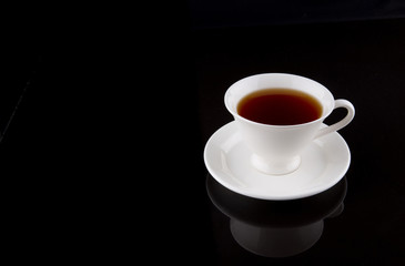 A cup of tea over black background