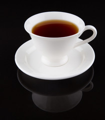 Obraz na płótnie Canvas A cup of tea over black background