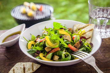 Tasty herb salad on a summer picnic table