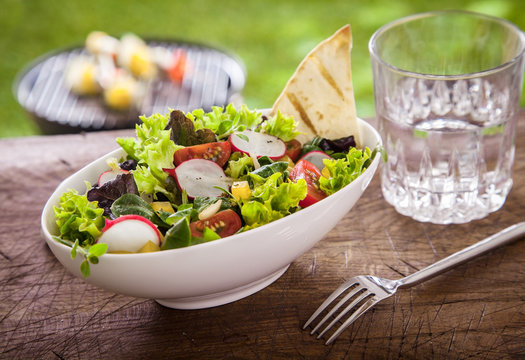 Healthy summer salad with a glass of fresh water