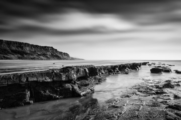 Beautiful black and white landscape of rocky shore at sunset