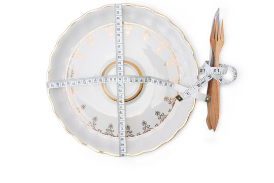 plate, a fork and a knife, entwined by measuring tape