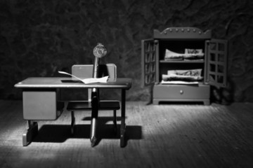 A conceptual image of an iron nail sitting behind a desk to stud