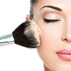 woman  applying dry cosmetic tonal foundation  on the face