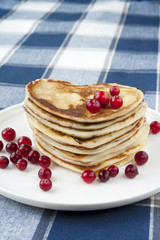 Heart shaped pancakes with cranberries on porcelain plate. Close