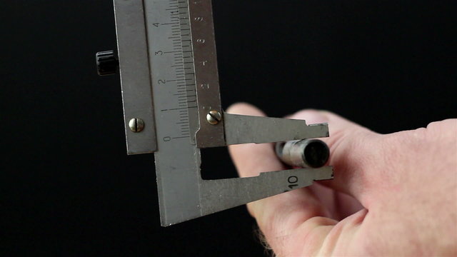 A caliper getting the measurement of the screw