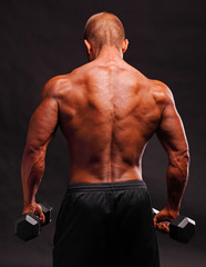 Fototapeta na wymiar Muscular male bodybuilder posing in studio