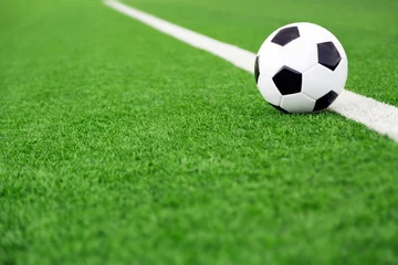 Abwaschbare Fototapete Ballsport Traditioneller Fußball auf Fußballplatz, grünes Feld trägt Hintergrund zur Schau