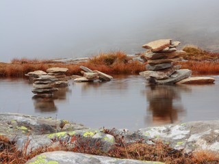 Fototapeta premium Piles of stones in the mountain lake