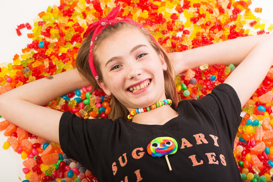 Young girl in a pool of colorful candy