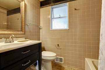 Beige bathroom with a black washbasin cabinet