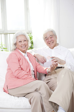 .Senior couple holding gift box.